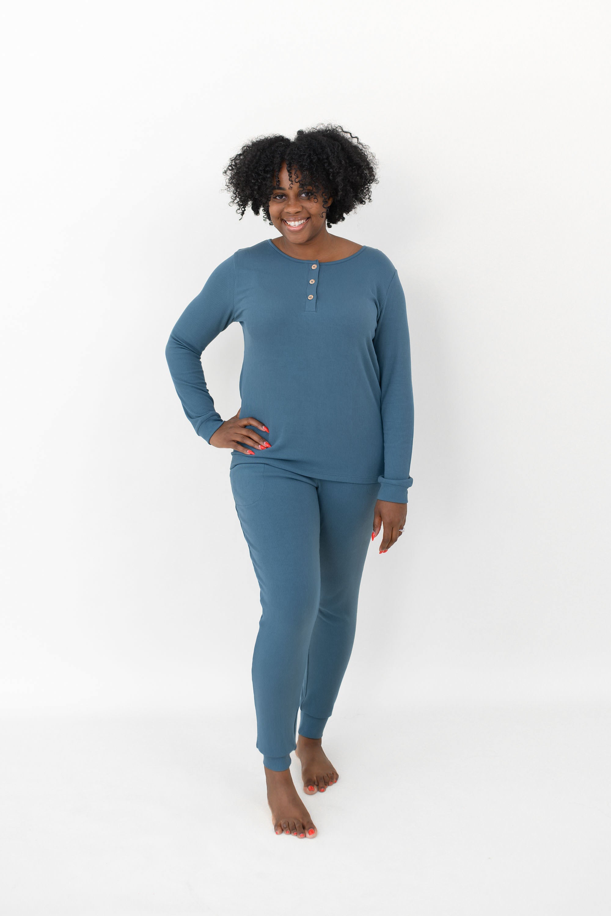 Smiling model wearing the Women’s Ribbed Henley Set in Atlantic with one hand on her hip