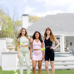 Three models standing in a yard with tennis balls wearing the Spring Bamboo sets in Basil, Thistle and Midnight