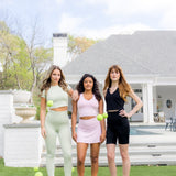 Three models standing in a yard with tennis balls wearing the Spring Bamboo sets in Basil, Thistle and Midnight
