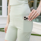 Bamboo Flex High Rise Biker Short in Basil shown on a female model with a phone in the shorts pocket

::: Model is 5'6" wearing size S ///