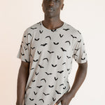 Modal wearing Men's Crew Neck Tee in Bats print over blue jeans on a beige background ::: Model is 6'1" wearing size L ///