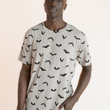 Modal wearing Men's Crew Neck Tee in Bats print over blue jeans on a beige background ::: Model is 6'1" wearing size L ///