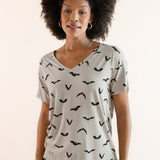 Modal wearing Women's Oversized V-Neck Tee in Bats print over light blue jeans on a beige background ::: Model is 5'9"" wearing size S ///