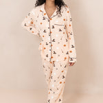 Smiling model standing with hand on her hip while wearing the Kyte Women's Long Sleeve Pajama Set in Bewitched