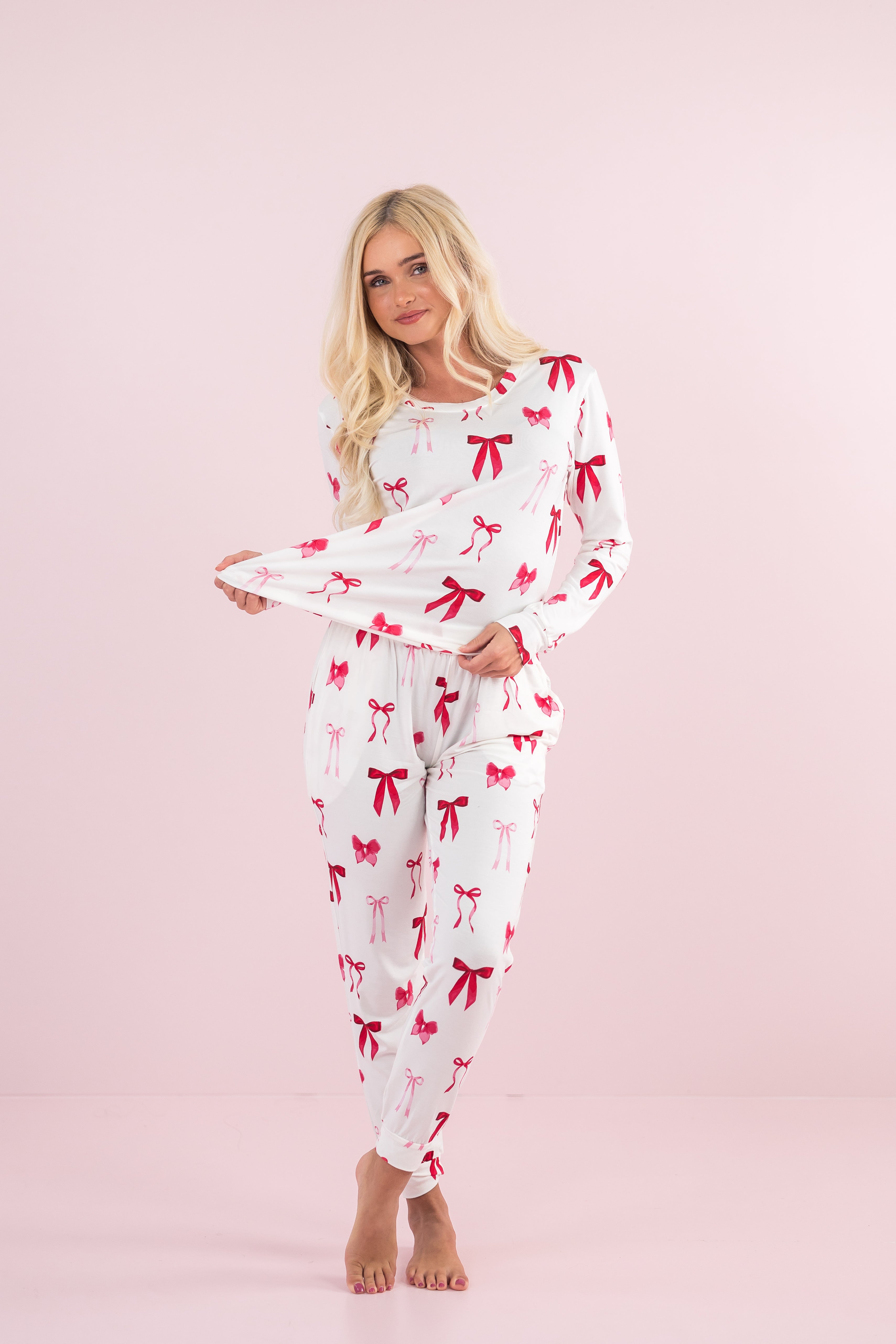 Model stretching bottom of top on the Bamboo Women's Jogger Pajama Set in Big Love Bow