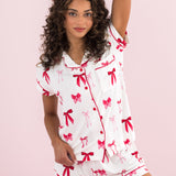 Woman modeling the Bamboo Women's Short Sleeve Pajama Set in Big Love Bow with hand over her head