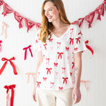 Model smiling to the side while wearing the Kyte Bamboo Women's Relaxed Fit V-Neck in Big Love Bow