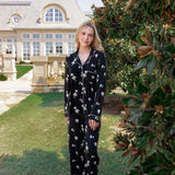 Woman outside soft smiling looking over her shoulder wearing a long sleeve pajama set in midnight magnolia. 
---1605 3