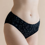 Close up of the Women’s Underwear in Midnight Leopard on a model paired with bra in cloud 

::: Model is 5'8" wearing size M ///
