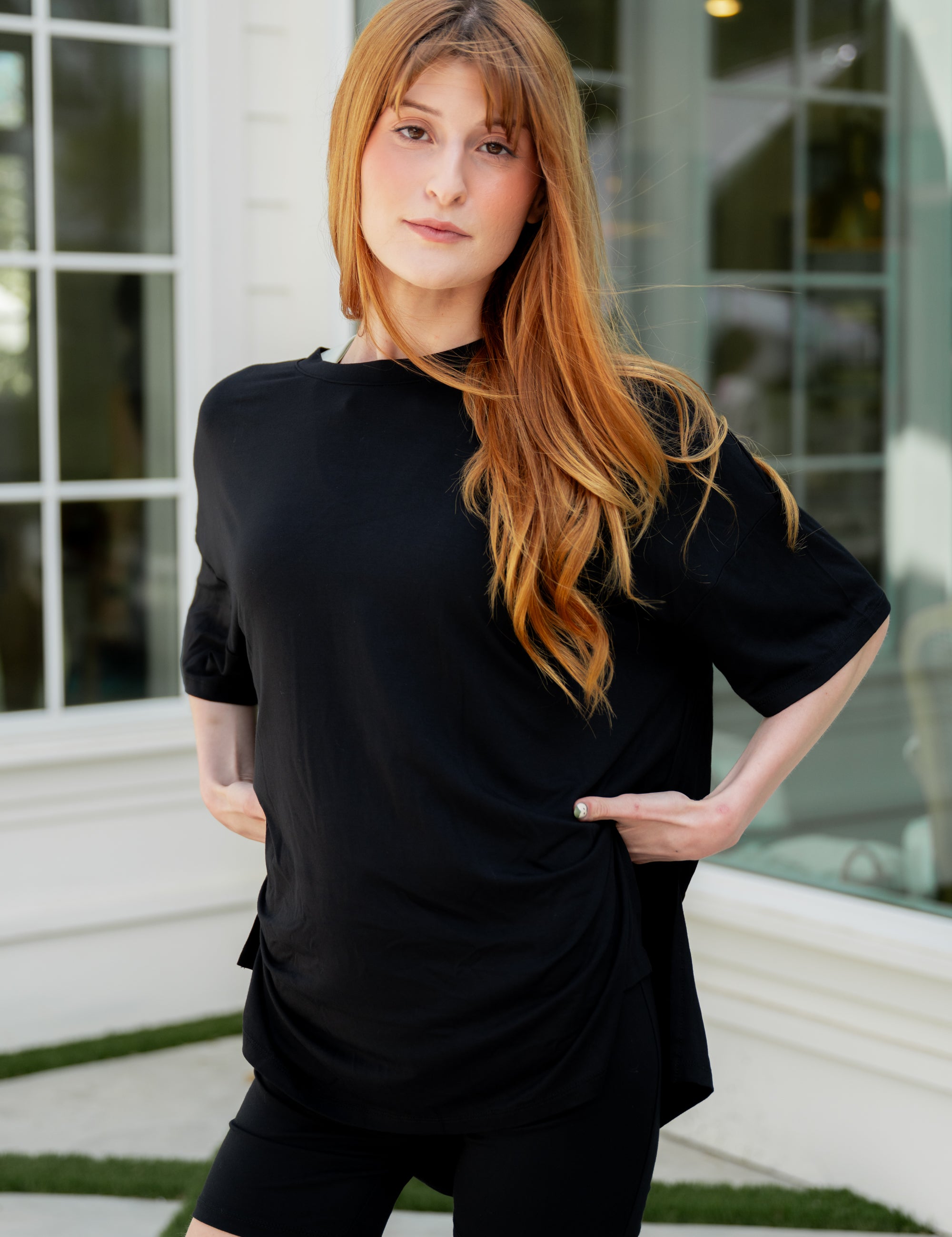 Woman wearing a black biker set outfit standing outdoors with a building in the background ::: Model is 5'6" wearing size S ///