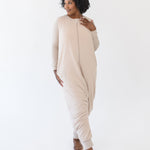 Model looking to the side while standing with one foot forward modeling the Adult Sleep Bag Walker in Bisque