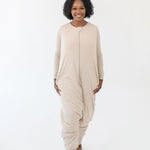 Woman modeling the Kyte Sleep Bag Walker in Bisque while standing in a white room