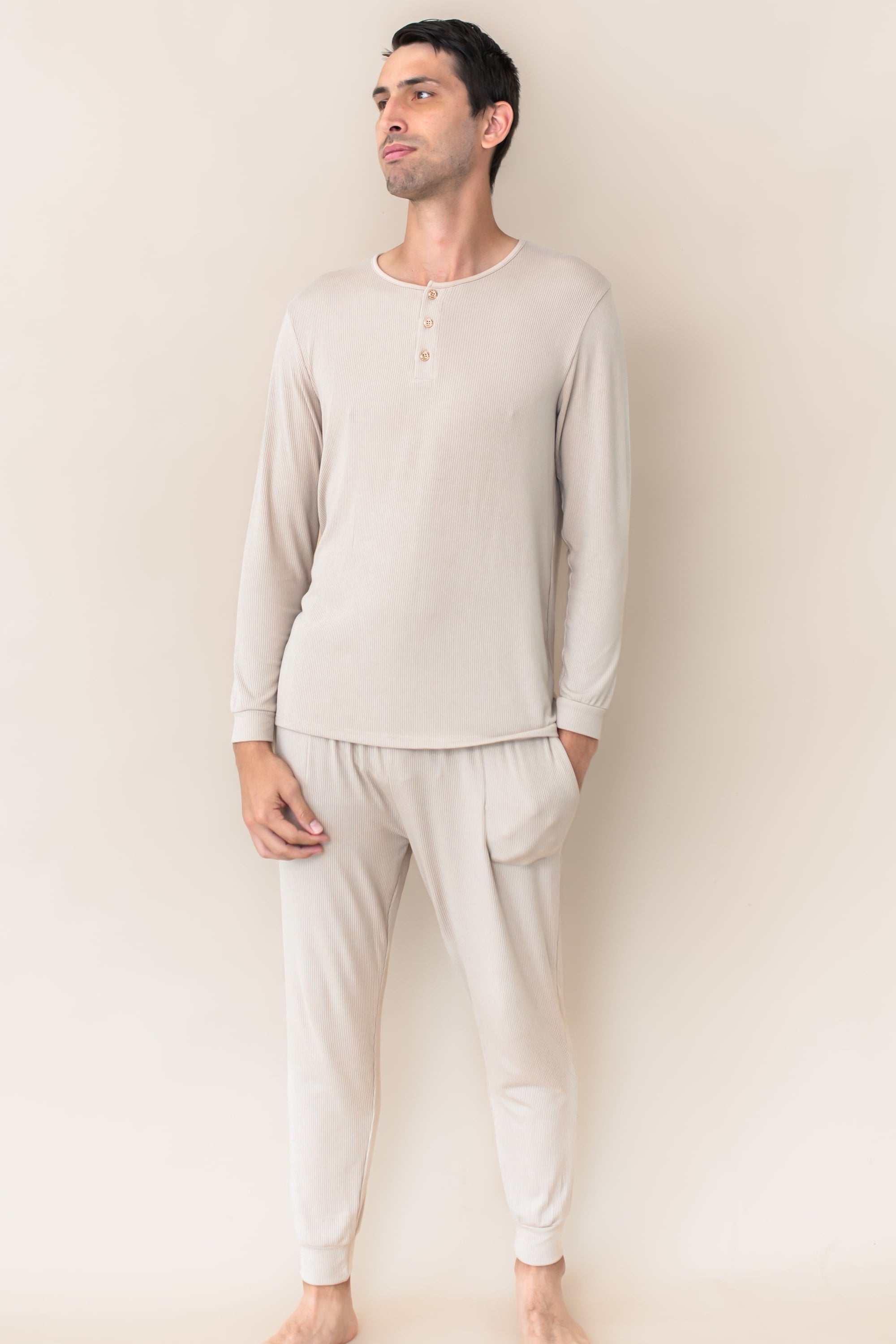 Male model wearing the Men's Ribbed Henley Set in Bisque in front of a cream colored background