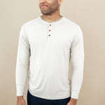 Smiling model looking to the side while wearing the Men's Long Sleeve Henley Tee in Bisque