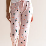 Model wearing pink Women's Lounge Pants in Sushi print under white camisole on a beige background