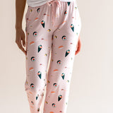 Model wearing pink Women's Lounge Pants in Sushi print under white camisole on a beige background