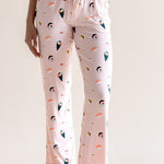 Model wearing pink Women's Lounge Pants with drawstring in Sushi print under white camisole on a beige background