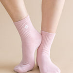 Pink socks worn by a person on a beige background