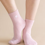Pink socks worn by a person on a beige background