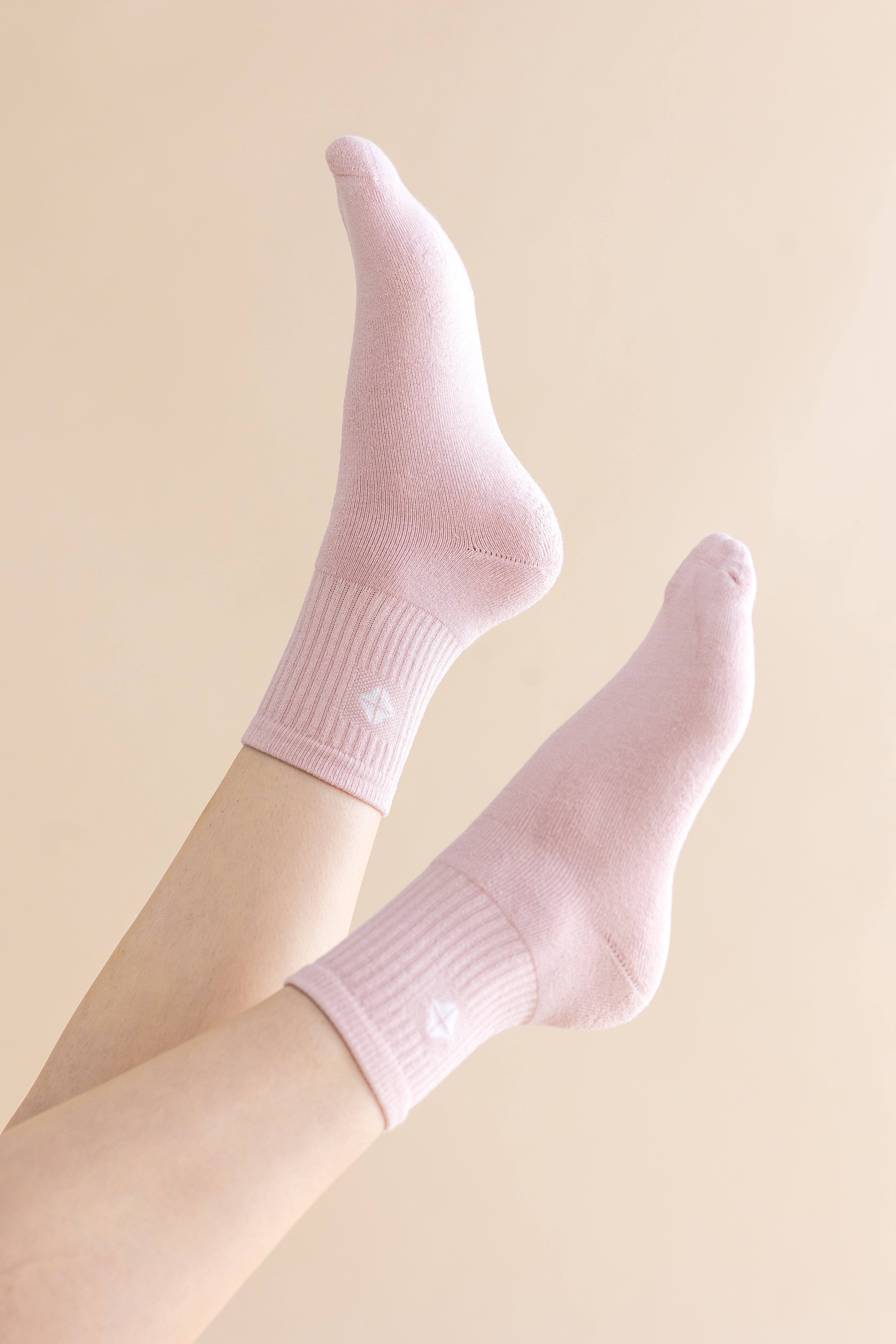 Pink socks worn on a light beige background