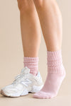 Person wearing pink socks and white sneakers on a beige background