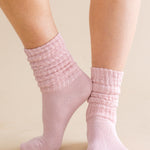Pink ribbed socks worn by a person on a beige background