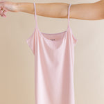 Pink tank worn by a person on a beige background