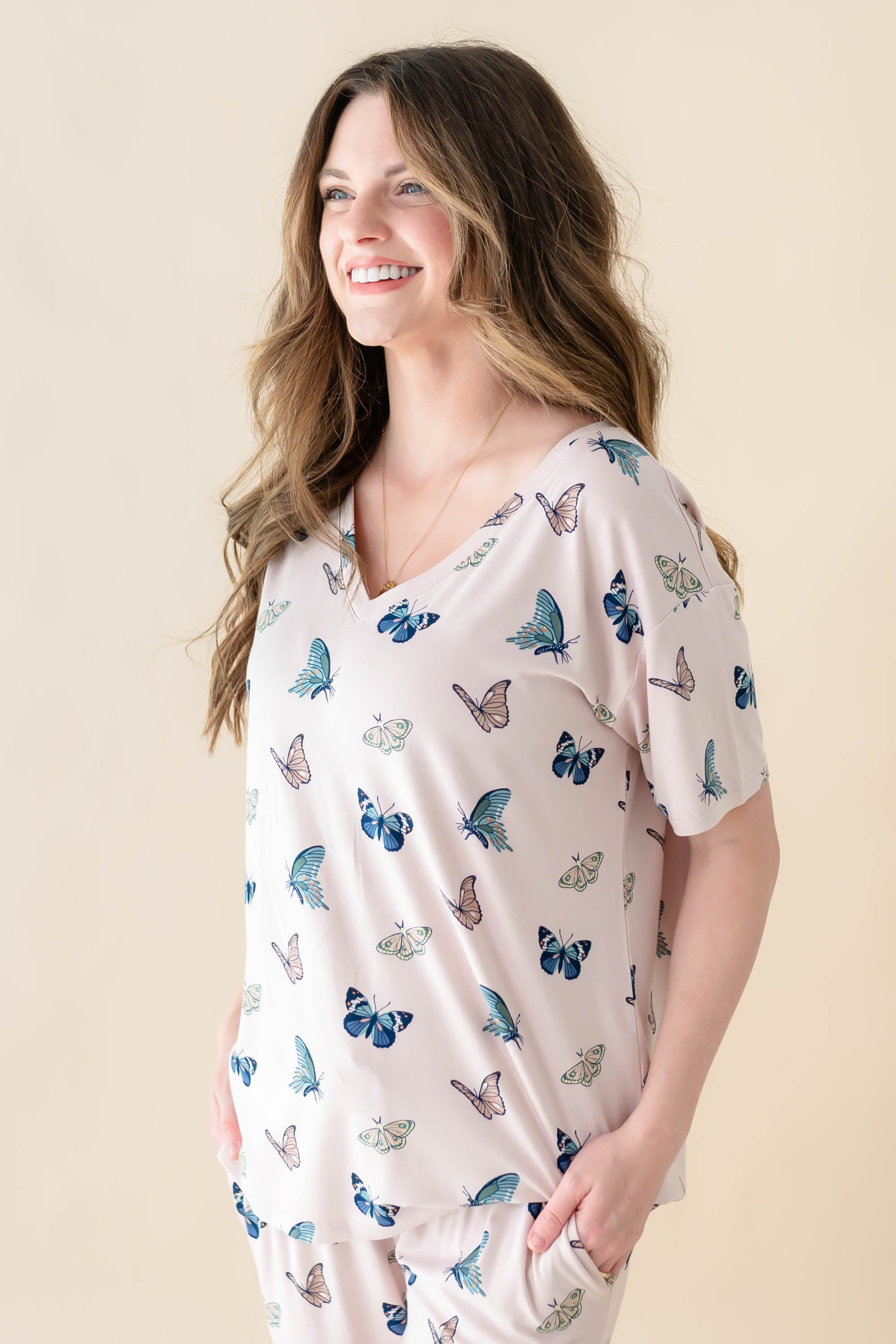 Female model wearing the Women's Relaxed Fit V-Neck in Blush Butterfly