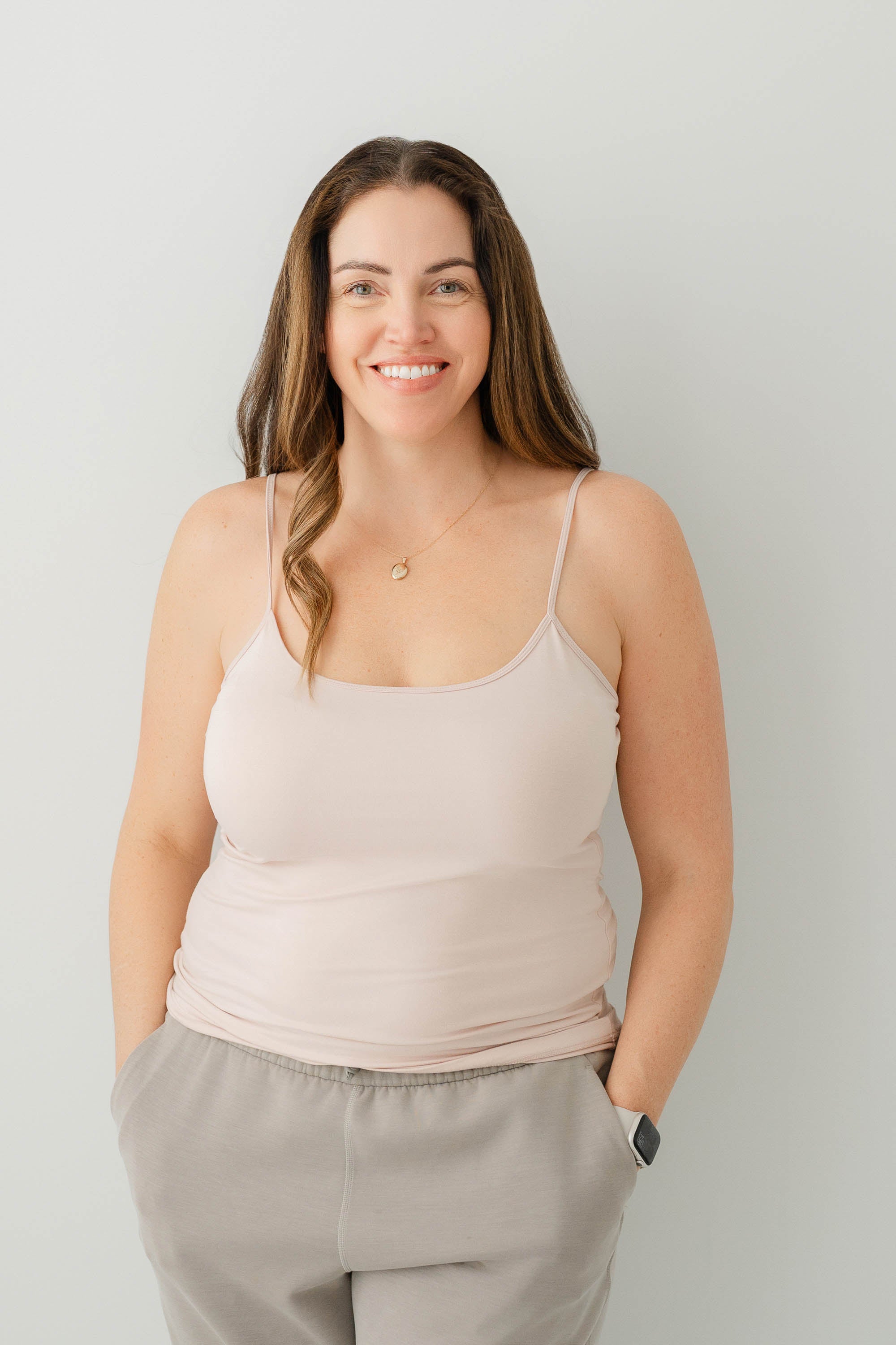 Female model wearing the Women’s Camisole in Blush and tan pants