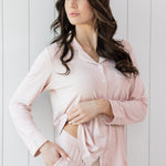 Model looking to the side while wearing the Kyte Long Sleeve Women's Pajama Set in Blush with Cloud Trim 