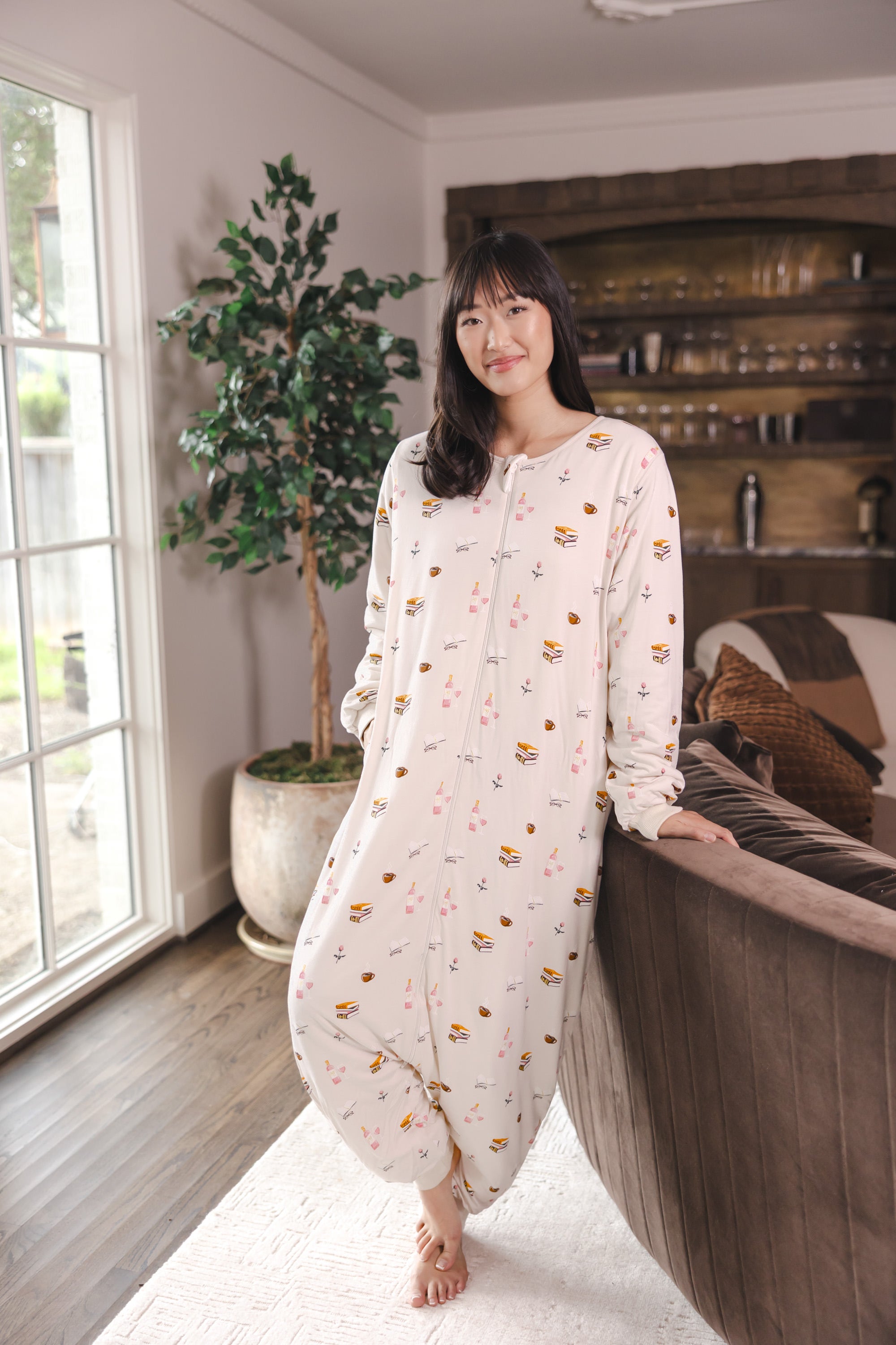Modal standing in a living room wearing Beige Long Sleeve Adult Sleep Bag Walker in Book Club print
::: Model is 5'9" wearing size S ///