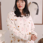 Modal posing in a room wearing Beige Long Sleeve Adult Sleep Bag Walker in Book Club print