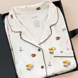 Long-Sleeved Women's Pajama Set in Book Club print packed in a box on a beige background