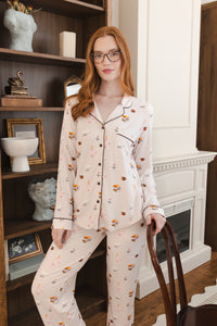 Modal wearing Long-Sleeved Women's Pajama Set in Book Club print posing in a living room