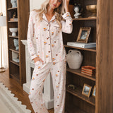 Modal wearing Long-Sleeved Women's Pajama Set in Book Club print standing against a book shelf