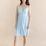 Woman wearing a light blue nightgown against a beige background