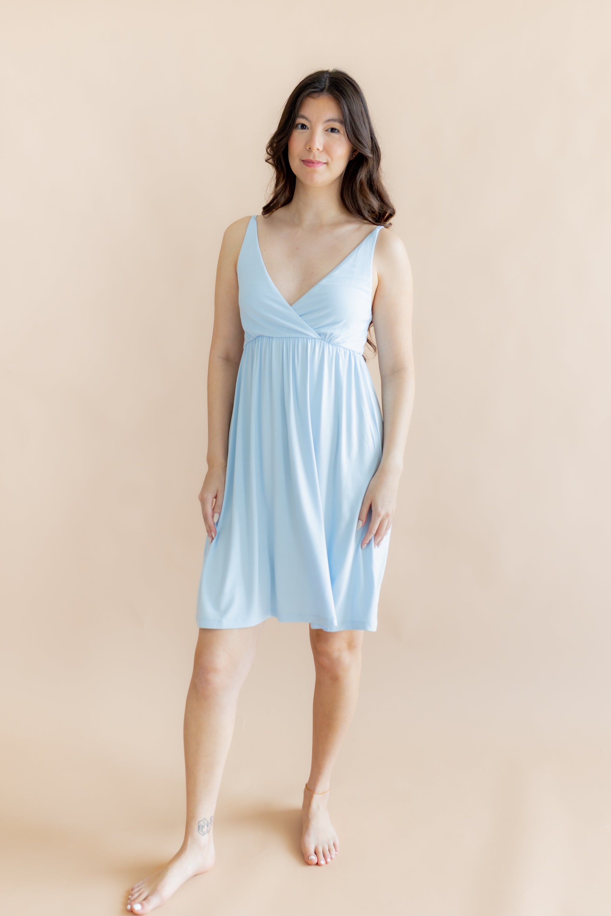 Woman wearing a light blue nightgown against a beige background