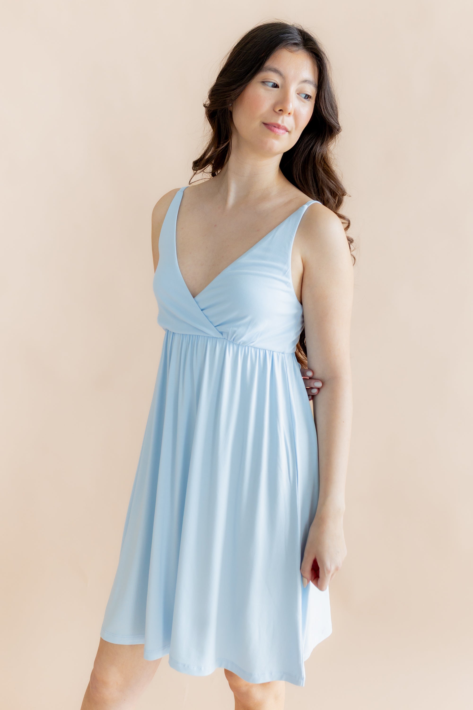 Woman wearing a light blue nightgown against a beige background