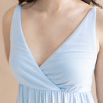 Light blue dress with a V-neckline on a beige background