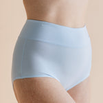 Light blue underwear worn by a person on a beige background