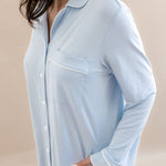 Light blue pajama top worn by a person on a beige background