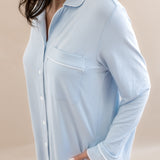 Light blue pajama top worn by a person on a beige background