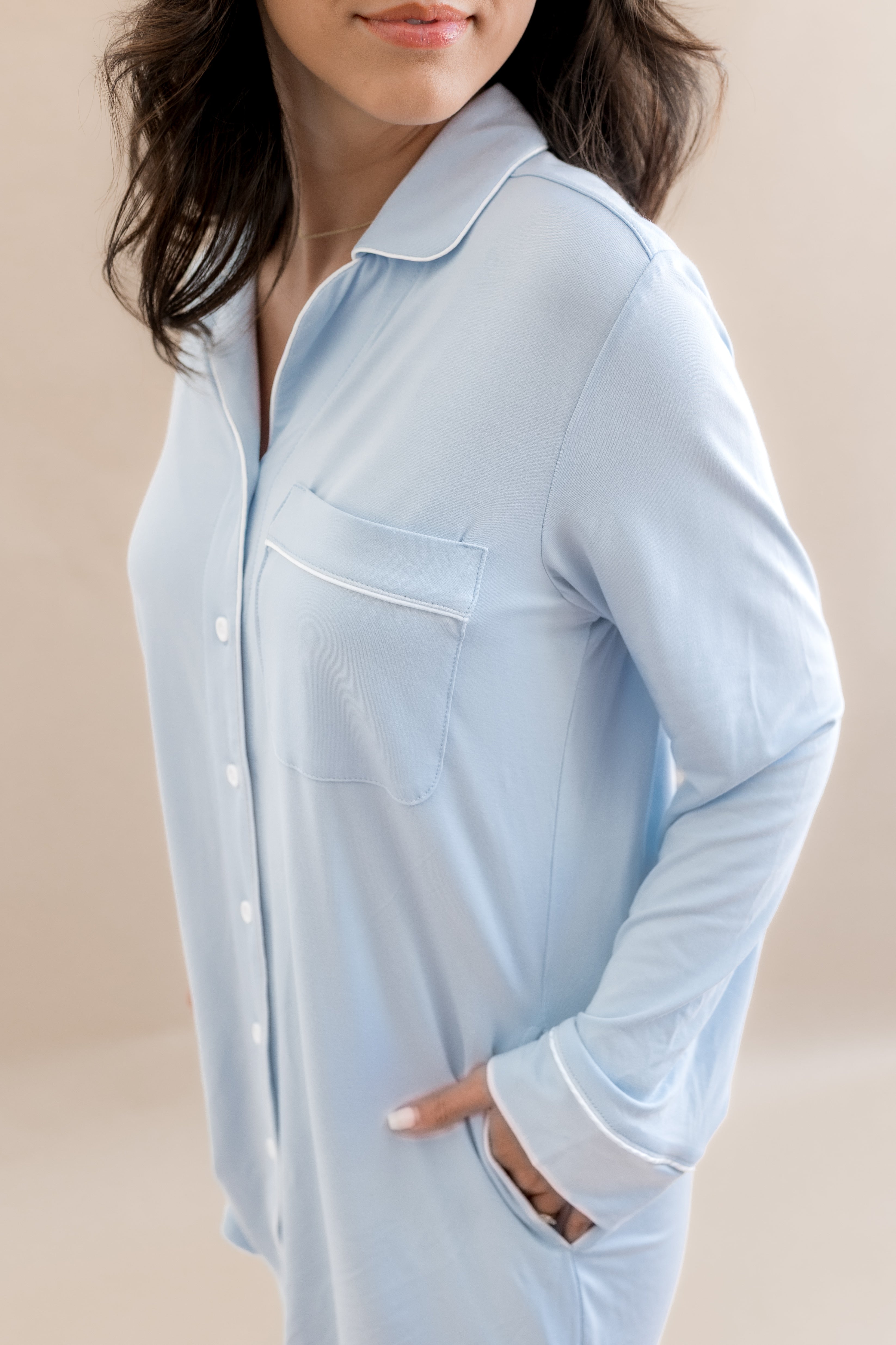 Light blue pajama top worn by a person on a beige background