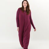 Smiling model walking towards camera while wearing the Adult Sleep Bag Walker in Burgundy 