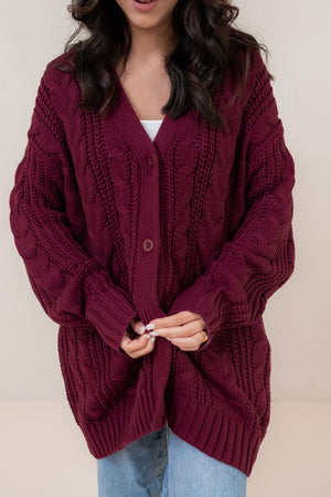 Person wearing a burgundy knitted cardigan against a plain background ::: Model is 5'2" wearing size S ///