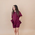 Women modeling the Women's Biker Short Set in Burgundy while looking to the side and smiling