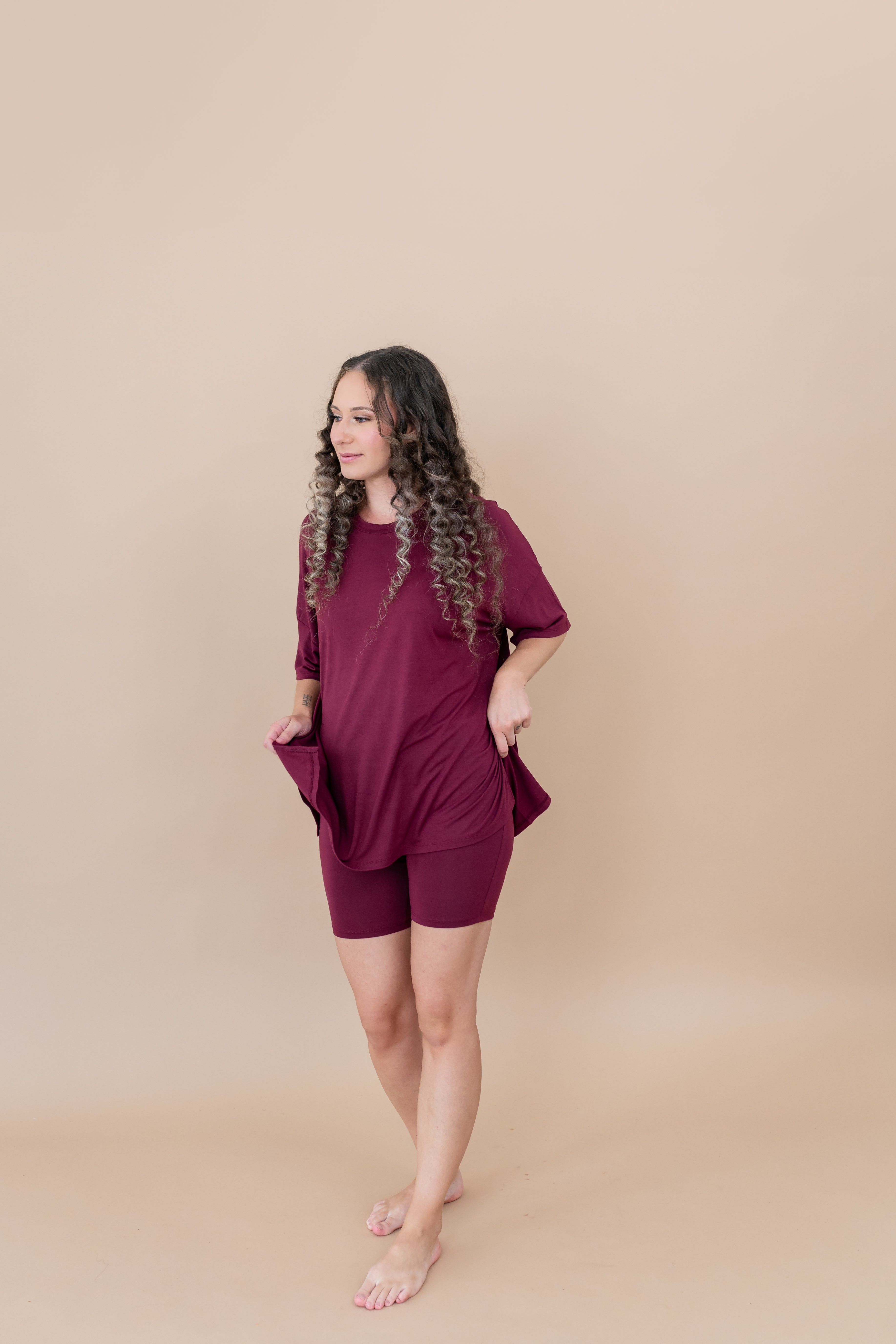 Women modeling the Women's Biker Short Set in Burgundy while looking to the side and smiling