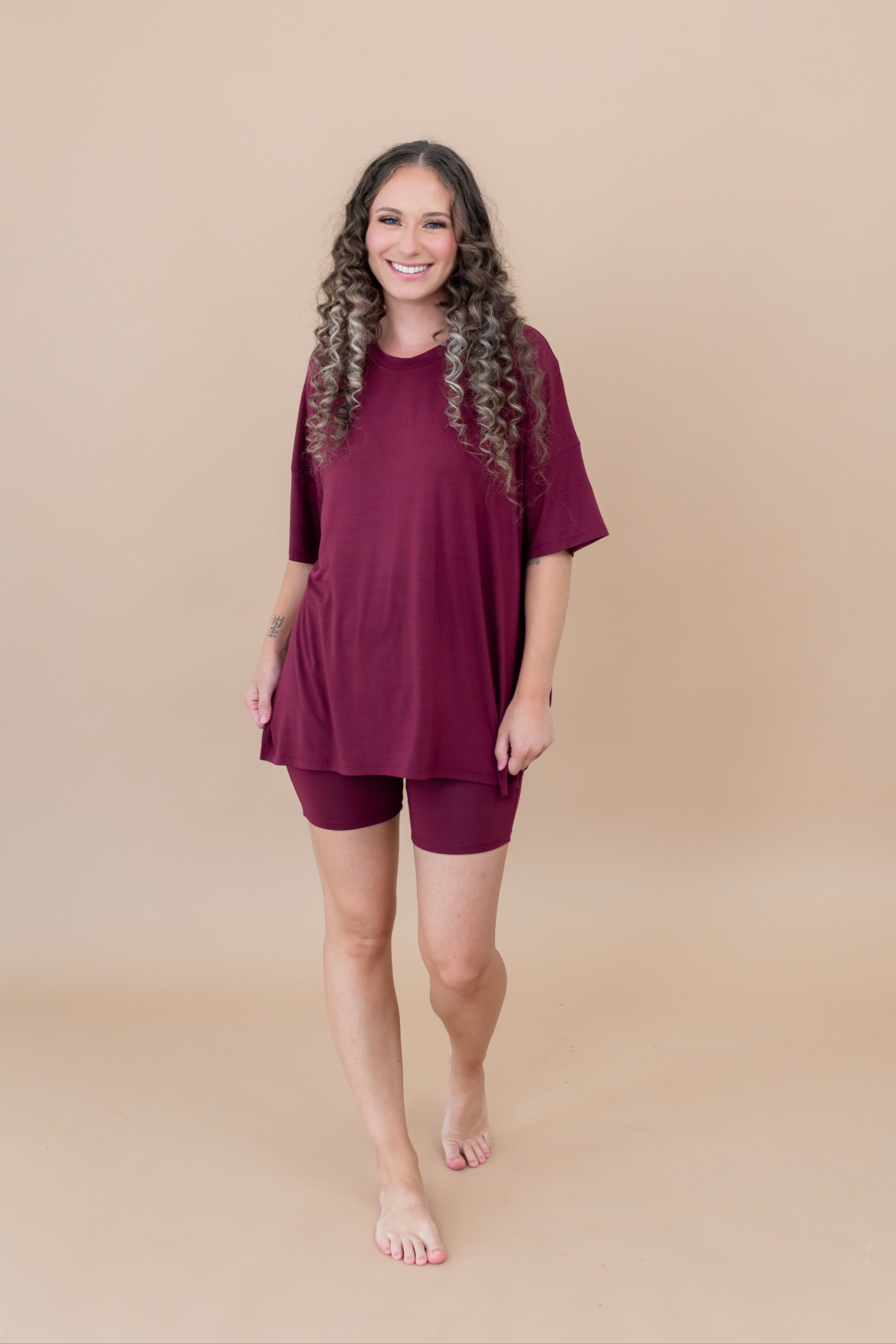 Smiling model walking towards camera while wearing the  Women's Biker Short Set in Burgundy
