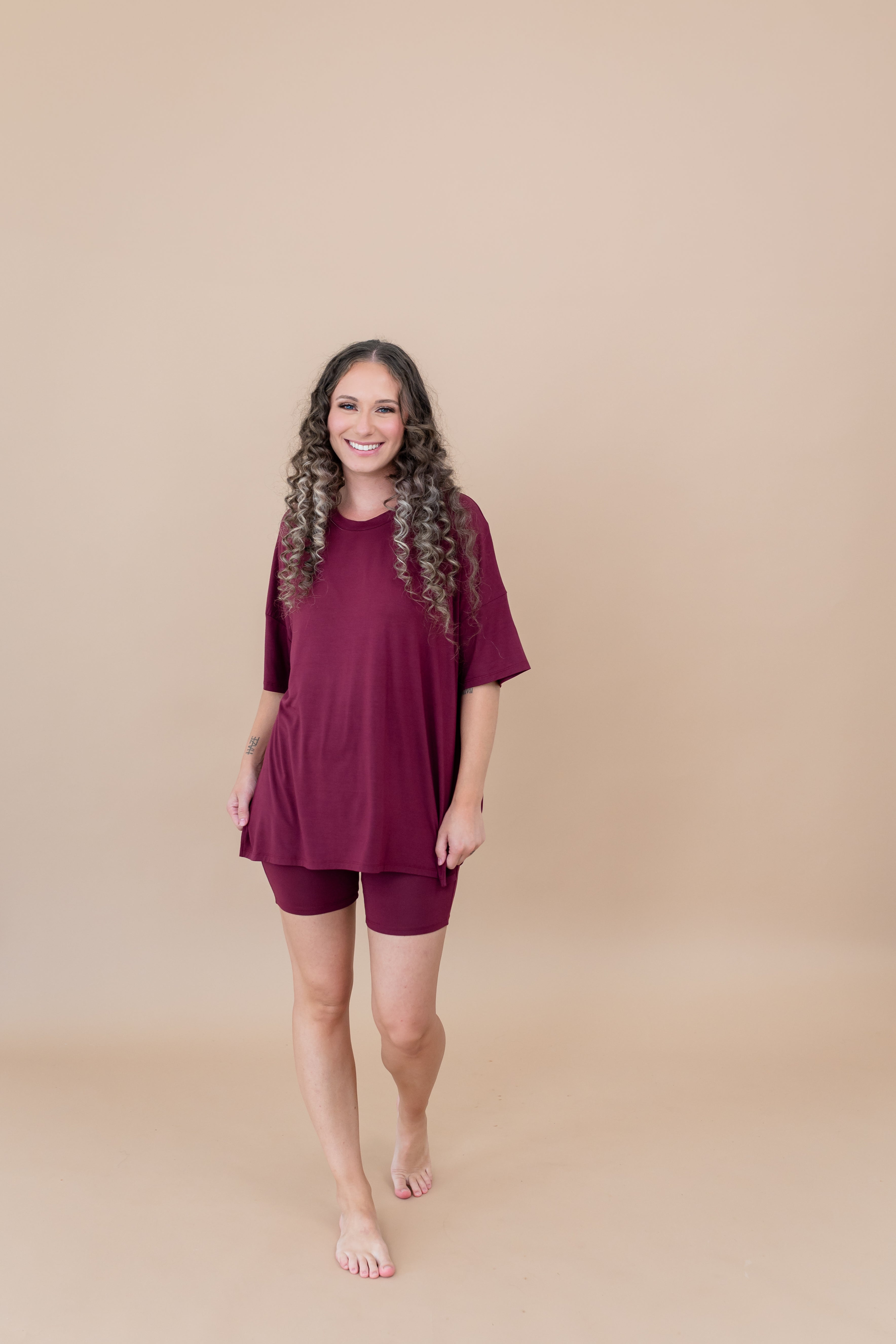 Smiling model walking towards camera while wearing the  Women's Biker Short Set in Burgundy
