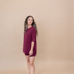 Model looking towards the back while modeling the Kyte Women's Biker Short Set in Burgundy